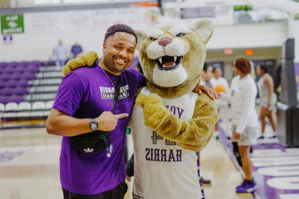 a person standing next to a mascot